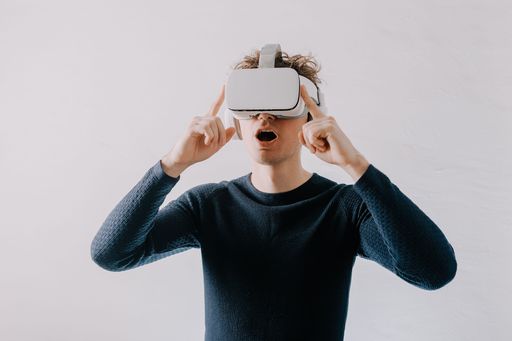 A surprised young man exploring a new universe with VR glasses