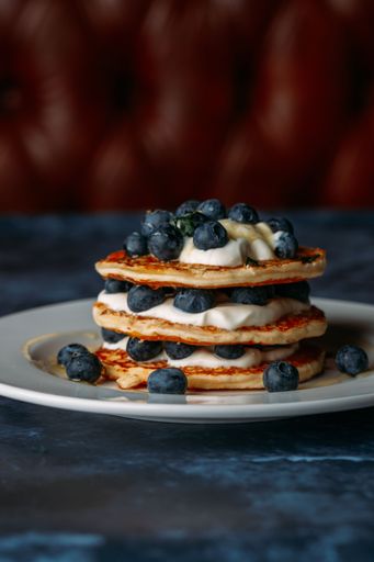 A freshly cooked pancake with blur berries on top