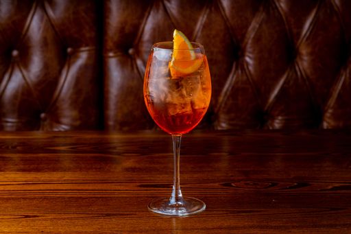A glass of Aperol Spritz on wooden table
