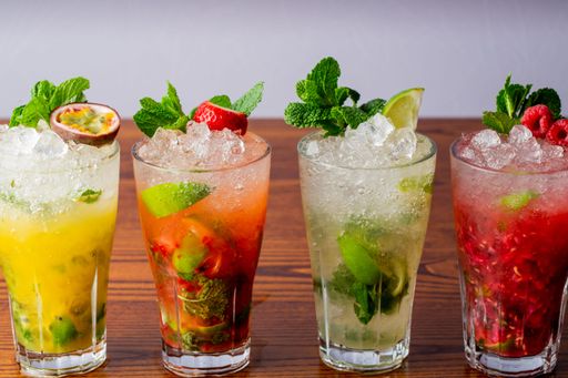 A variety of mojitos in a row on wooden table