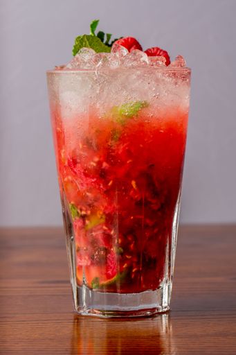 A vertical closeup of Raspberry mojito on wooden table