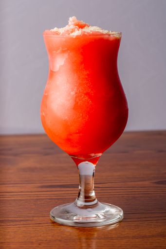A vertical shot of a glass of watermelon juice on wooden table