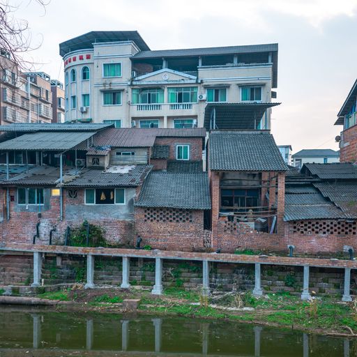 A view of houses and buildings by the bridge reflected on the lake