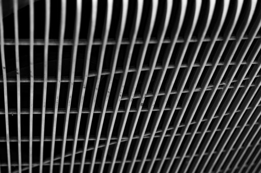 A macro shot of metal mesh in front of a black surface