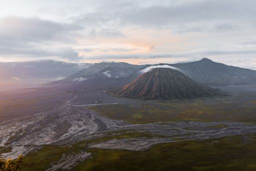 An aerial shot of Mount Bromo under a light cloudy sky