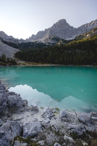 A vertical shot of landscape the Lake Sorapis in Italy under bright sky