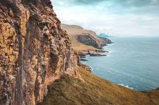 A beautiful scenery of rocky cliffs on the seacoast on the island of mykines in the Faroe