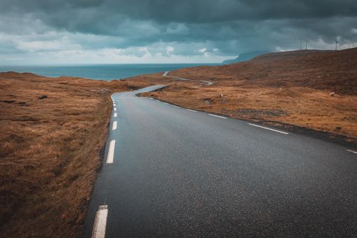 An empty road in a desert area in the Faroe Islands at daytime