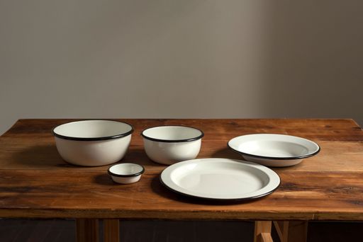 A closeup shot of artisan style bowls and plates on wooden table