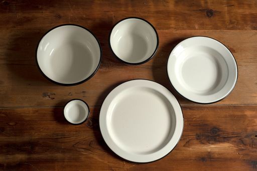A top view of artisan style bowls and plates on wooden table