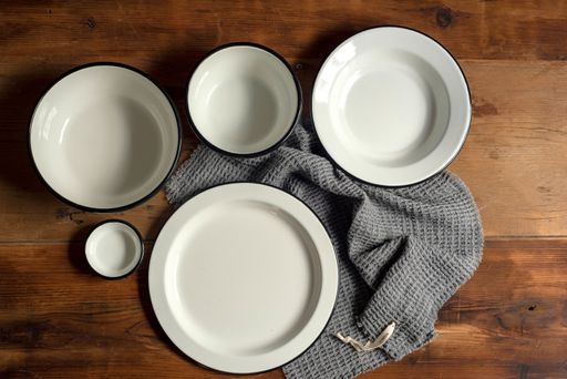 A top view of artisan style bowls and plates on wooden table
