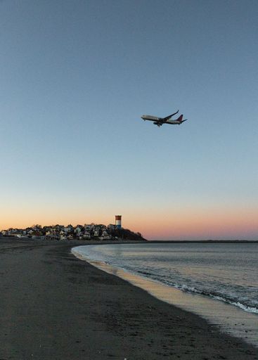 A vertical Delta Air Lines airplane flying in the sky at sunset. Everett, United States.