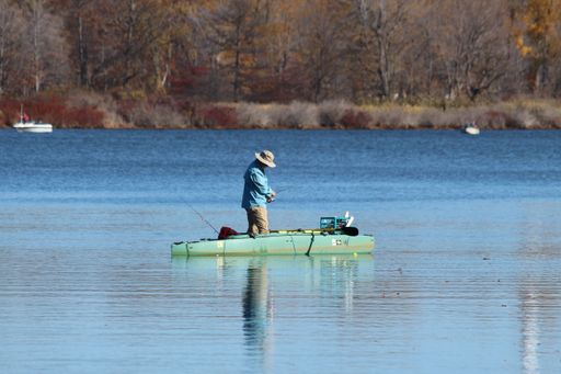 A man on a kayak fishing at Presque Isle Bay in Erie on a beautiful autumn day