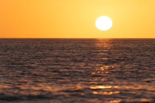 A selective focus of beautiful sea waves reflecting yellow sky at sunset on Marco Islands,Florida, USA