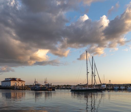 A scenic view of sailboats in a port during a beautiful sunset