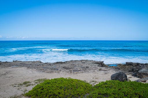 A beautiful view of an ocean waves hitting the coast of the Kaena Point Beach, Hawaii