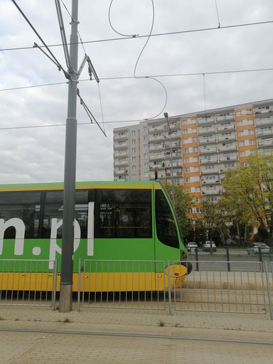 The waiting green tram and an apartment building in the Stare Zegrze district.