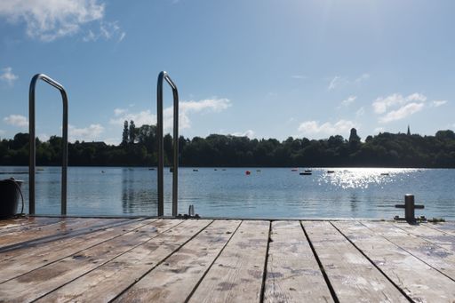 A dock for small boats and many diving buoys in the lake on a sunny day in Germany