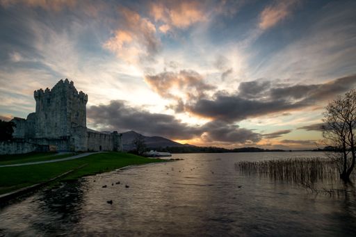 A beautiful lake in front of the old Roscommon Castle in Ireland under a cloudy sky