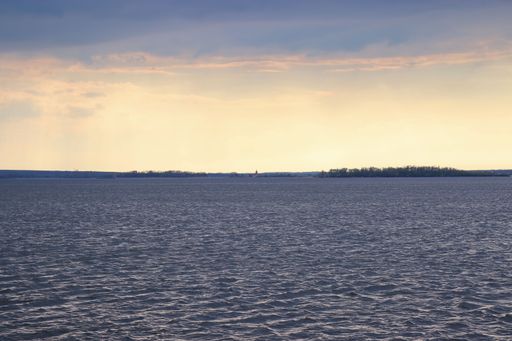 A dark sky with sun above the lake during the storm near Strachotin, Czech republic