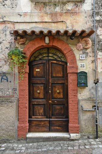 A vertical shot of an old wooden door in Lenola. Province of Latina, Lazio region, central Italy.