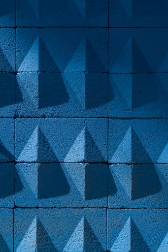 A vertical shot of a blue concrete wall with rhombuses