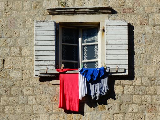 A drying laundry hanging outside from an old wooden window