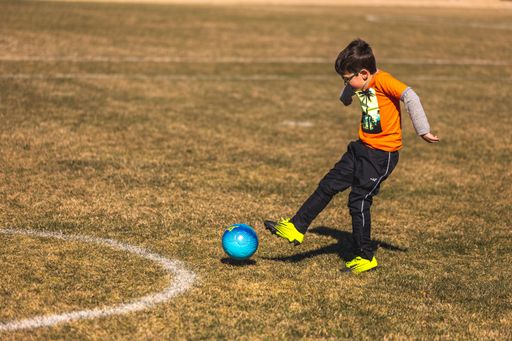 Young boy is hitting the ball. Youth Spring Soccer Games near the heart of down town Fort Worth in Texas