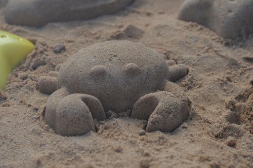 A close-up shot of a crab made of sand on the beach
