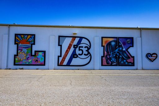 The street art on the white wall against the blue sky. Lubbock, Texas.