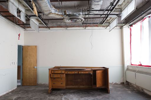 The air condition system in an empty and dirty room with old wooden desk