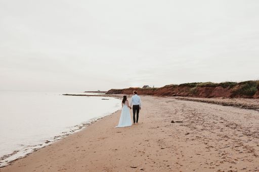 A closeup of a couple walking on the sandy beach in Canada