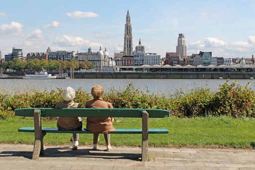 The two elder females sitting on the bench on the riverside against the Ghent
