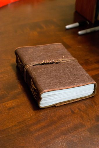 A closeup shot of a closed notebook on the wooden table