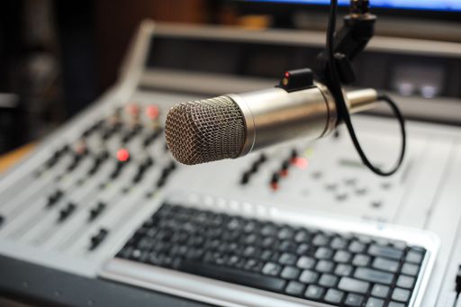 A selective focus shot of a professional condenser microphone in a recording studio