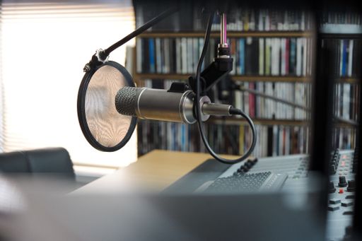 A selective focus shot of a professional condenser microphone in a recording studio