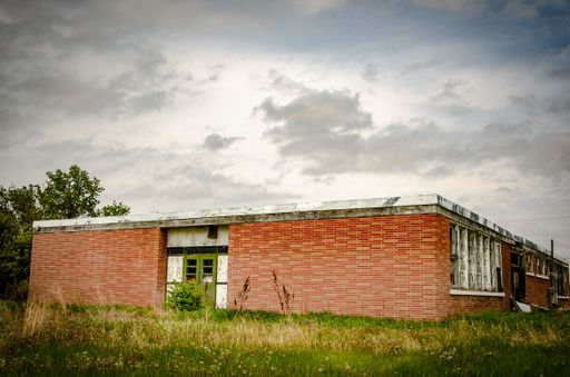 An old, aged and abandoned brick house under the cloudy and rainy sky