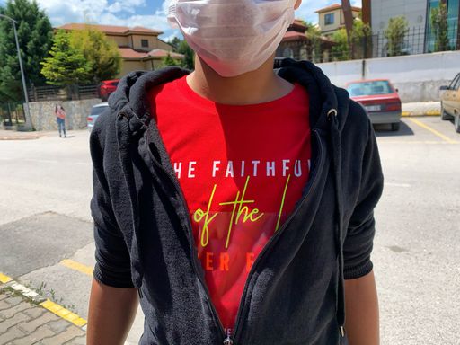 A shallow focus shot of a fashionable bright t-shirt on a teenager with medical mask