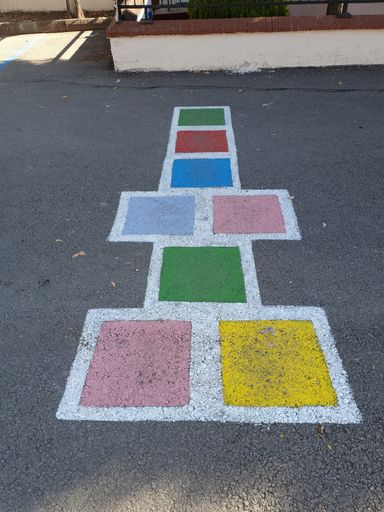 A vertical shot of a chalk colorful game on an asphalt road