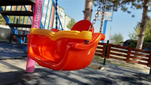 A closeup shot of a plastic colorful swing in a playground