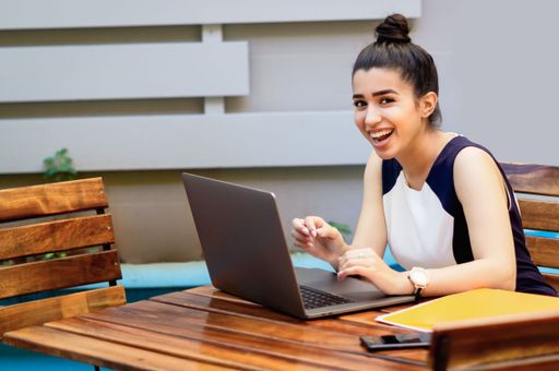 A close up woman with laptop working outdoors