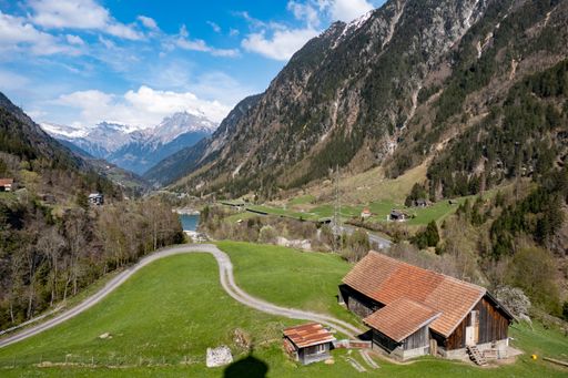 A scenic view of a wooden house in a valley in Switzerland