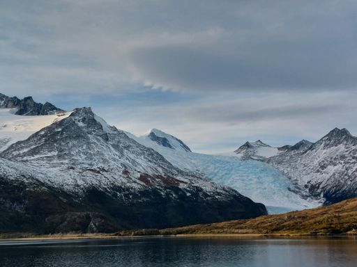 A beautiful landscape of a lake by the snowy mountains