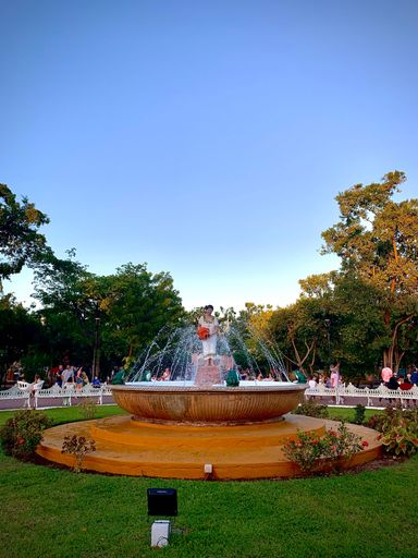 A vertical shot of a beautiful fountain in the park during sunset in Yucatan, Mexico