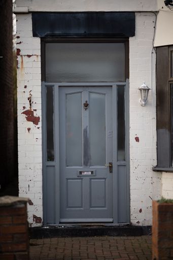 A vertical shot of a gray door of a residential building