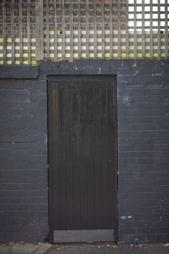 A vertical shot of an old wooden door of a residential building