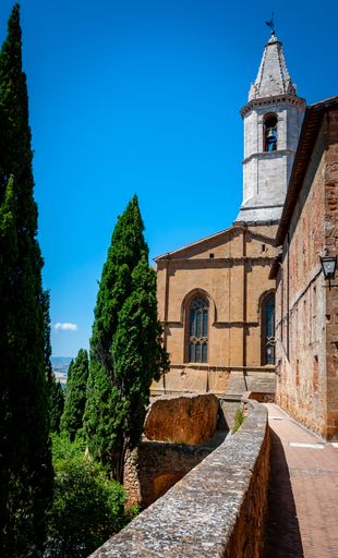 A vertical shot of the bell tower and cypress trees in Montepulciano, Tuscany, Italy