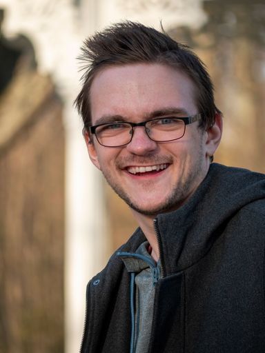 A young Caucasian cheerful guy wearing glasses