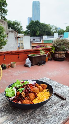 A vertical shot of a vegan meal with red lentils, soy meatballs, beetroot on the wooden table