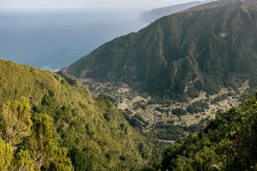 A high angle shot of a small village between mountains by the ocean in Madeira island, Portugal